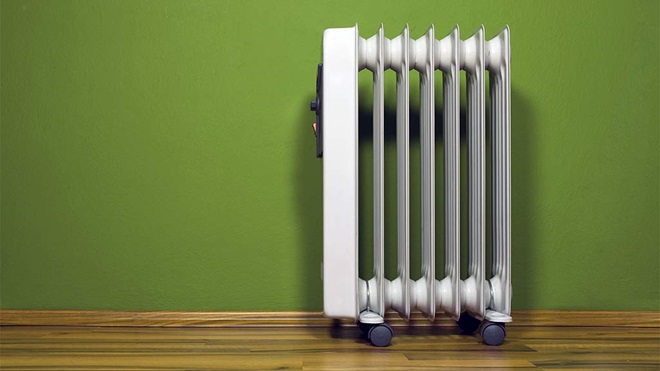 electric oil column heater against green wall